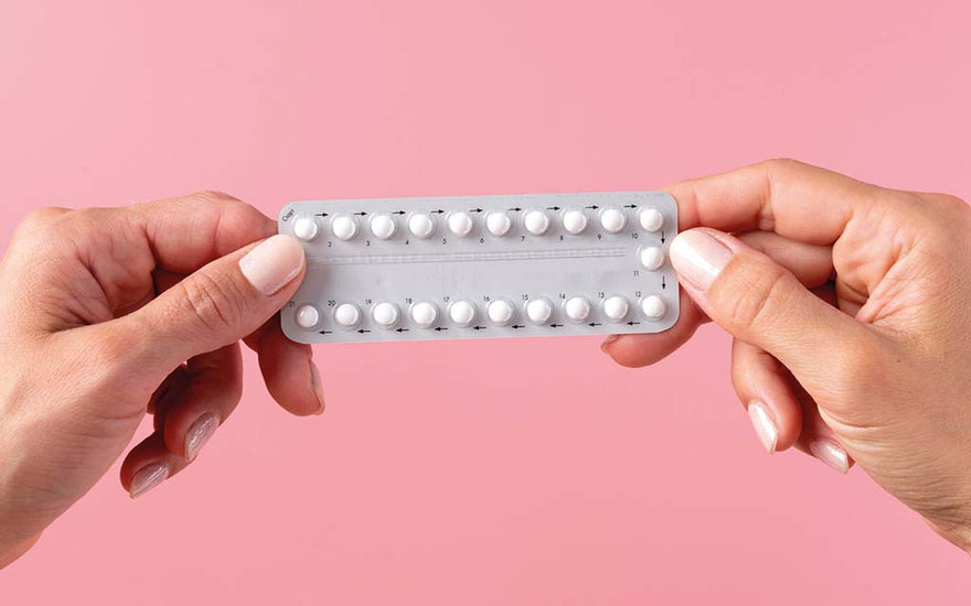 A contraceptive pill pack next to a calendar with various dates marked